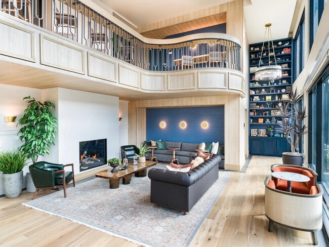 Expansive clubroom with fireplace and lounge seating at Modera University Park. - Modera University Park Apartments