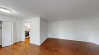Located at 1518 Village Dr in Wilmington, NC, this one-bedroom, one-bathroom unit offers a practical and well-organized single-floor layout. Rich hardwood flooring runs throughout the main living areas, complementing the clean white walls and textured ceilings to create a bright, neutral interior.

The living room is the largest open space in the unit, featuring a wide front window that allows natural light to filter in alongside a bold green entry door that adds a touch of character. A dedicated hallway connects the main living space to the private areas of the unit.

The kitchen is efficiently designed with white cabinetry, ample counter space, a double stainless steel sink, and a stainless steel dishwasher. An electric range and overhead microwave complete the appliance package, making the kitchen both functional and well-equipped.

The bedroom is a generously sized private retreat, featuring plush carpeting, a ceiling fan with light fixture, a built-in louvered closet, and a small built-in desk surface — ideal for a work or study area. The room connects conveniently to the hallway and bathroom.

The bathroom features a full tub-shower combination lined with clean white tile and equipped with stainless steel grab bars, providing both comfort and accessibility. Overall, this unit offers a clean, functional living environment in a convenient Wilmington location.