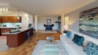 This single-floor residence offers a thoughtfully designed layout that balances comfort and functionality across its living spaces. The open-concept living room is generously proportioned, featuring warm parquet flooring and a breakfast bar that connects seamlessly to the kitchen, making it ideal for both relaxing and entertaining. The kitchen is fully equipped with rich wood cabinetry, granite countertops, a teal tile backsplash, and a full suite of stainless steel appliances including a gas range, built-in microwave, dishwasher, and refrigerator. An adjacent dining area with large windows and vertical blinds allows natural light to flow freely into the space.

The bedrooms are comfortably sized, each with parquet flooring and good natural light. The primary bedroom features a bold accent wall and direct access to a dedicated closet. A secondary bedroom offers a bright, airy feel with large windows overlooking greenery.

Two bathrooms serve the residence, each finished with tile flooring, rich wood vanities, and granite countertops. One bathroom features a vibrant orange accent wall, while the other is appointed in soft taupe tones, both conveying a clean and modern aesthetic. The overall ambiance of the space is warm, cohesive, and move-in ready.
