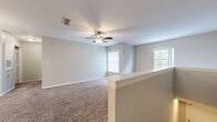 Located at 1355 Bradley Blvd in Savannah, Georgia, this single-floor home offers a well-organized layout designed for comfortable everyday living. The open-concept living area is generously proportioned, featuring wall-to-wall carpet, soft neutral-toned walls, and multiple windows that allow natural light to fill the space. Ceiling fans are present throughout, providing both comfort and airflow. A half-wall partition with a decorative post defines the living area while maintaining an open, connected feel.

The kitchen is equipped with light wood cabinetry, stone-patterned countertops, and stainless steel appliances including an electric range and over-the-range microwave. Durable wood-look vinyl flooring runs through the kitchen, which connects conveniently to a utility area. A pass-through counter with a sink bridges the kitchen and living space, ideal for casual dining or entertaining.

The bedrooms are carpeted and well-lit, each featuring ceiling fans and windows with vertical blinds. Closet access is available within the bedroom areas. The bathrooms are clean and functional, each featuring a tiled tub-and-shower combination, a wood-vanity with a white countertop, and tile flooring. Overall, the home presents a practical and move-in ready layout in a residential Savannah neighborhood.