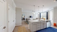 Located at 1235 Ashley Gardens Blvd in Charleston, SC, this thoughtfully designed one-bedroom, one-bathroom residence offers a comfortable and functional single-floor layout. The open-concept kitchen and living area serves as the heart of the home, featuring gray shaker-style cabinetry, granite countertops, a large kitchen island with undermount sink, stainless steel appliances, and pendant lighting. Hardwood-style flooring flows throughout the main living areas, complemented by crown molding and ceiling fans that add a polished touch. The living room provides generous space for both lounging and dining, with large windows dressed in navy curtains that invite natural light and offer outdoor views. The bedroom is a serene retreat, carpeted for comfort, with multiple windows, a ceiling fan, and direct access to a dedicated closet outfitted with wire shelving and hanging storage. The full bathroom features a granite vanity with gray cabinetry, wood-look tile flooring, and a shower-tub combination. Neutral tones throughout create a clean, cohesive aesthetic, making this well-equipped Charleston residence both practical and inviting.