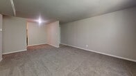 Located at 6000 Amberwood Rd in Baltimore, MD, this single-floor, 2-bedroom unit offers a straightforward and functional layout designed for comfortable everyday living. The floor plan connects the rooms via a central hallway, providing an organized flow throughout the space. Both bedrooms feature neutral-toned, wall-to-wall carpeting that adds warmth underfoot and is complemented by clean white trim and soft gray walls. The primary bedroom is a well-proportioned space that includes a closet and benefits from natural light streaming in through a window overlooking greenery outside. The second bedroom similarly features carpeted flooring and its own window with outdoor views of surrounding trees, creating a calm, natural atmosphere. Each bedroom is equipped with closet access and ceiling light fixtures. The living area is a notably open and spacious room with large windows that allow abundant natural light to fill the space, offering views of the lush exterior landscape. Visible HVAC vents are integrated into the ceiling throughout. The unit also includes a bathroom with standard fixtures. Overall, the space presents a clean, neutral palette that provides a versatile canvas for personalization.