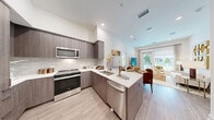 Located at 1881 N Rollins Rd in Burlingame, CA, this thoughtfully designed 2-bedroom, 1-bathroom residence offers a comfortable and contemporary living experience on a single floor. The open-concept layout seamlessly connects the kitchen, dining, and living areas, creating a bright and cohesive communal space. The modern kitchen features wood-toned cabinetry, a subway tile backsplash, white quartz countertops, stainless steel appliances including a range, microwave, and dishwasher, and light wood-look flooring that flows throughout the main living areas. The living room is bathed in natural light from large sliding glass doors that open to an outdoor area, enhancing the sense of space and openness. The primary bedroom is a well-proportioned retreat with a large window framing green outdoor views. The bathroom is elegantly appointed with a dual-sink floating vanity, wood-toned cabinetry, a large wall mirror, marble-style tile flooring, and a walk-in shower. A second bathroom view reveals a soaking tub option and direct access to a closet. Multiple closets throughout the home, including a spacious walk-in, provide ample storage. A dedicated laundry area and hallway complete this well-planned residence.