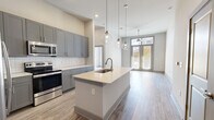 Located at 1989 Cheshire Bridge Rd NE in Atlanta, GA, this well-appointed 2-bedroom, 2-bathroom residence offers a thoughtfully designed single-floor layout. The open-concept living and kitchen area serves as the heart of the home, featuring wood-look flooring, neutral tones, and impressive ceiling height that enhances the sense of space. The kitchen is a standout, showcasing grey shaker-style cabinetry, a white subway tile backsplash, stainless steel appliances, and a central island with a light quartz countertop and undermount sink, all illuminated by a trio of globe pendant lights. Large glass doors flood the living area with natural light and provide access to a private balcony. The primary bedroom is generously sized, offering large windows and ample natural light, while the second bedroom provides a comfortable and versatile space. Both bathrooms are well-finished, with one featuring a soaking tub framed by classic white subway tile. Storage is plentiful throughout, with five closets including walk-in options with wire shelving. Additional conveniences include a dedicated laundry area and a utility room, completing this functional and modern Atlanta residence.