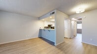 Located at 1333 N Dysart Rd in Avondale, Arizona, this single-floor unit offers a practical and well-appointed layout. Light wood-style flooring runs throughout the space, creating a cohesive and clean aesthetic. The open-concept living room and kitchen share a bright, airy feel, with the living area benefiting from a large window fitted with horizontal blinds that invites natural light. A textured ceiling adds architectural character to the room.

The kitchen is efficiently designed and connects to the living area via a pass-through counter with a breakfast bar overhang — ideal for casual dining or additional workspace. White cabinetry with brushed nickel hardware lines the kitchen walls, complemented by a gray subway tile backsplash and stainless steel appliances, including a full-size refrigerator, electric range, and dishwasher.

The bathroom is neatly finished with white cabinetry, a light quartz-style countertop, a single-basin sink, and a full tub-shower combination enclosed by a white surround. The same light wood flooring continues here, maintaining a consistent look throughout the unit. Overall, the space presents a clean, modern interior suitable for comfortable everyday living.