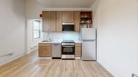 Located at 1707 Main St in La Crosse, Wisconsin, this efficiently designed one-bedroom, one-bathroom unit offers a well-organized single-floor layout that makes smart use of every square foot. The light wood laminate flooring runs throughout, creating a warm and cohesive feel across all rooms.

The kitchen is a standout feature, equipped with warm-toned wood cabinetry extending to the ceiling for ample storage, stainless steel appliances including a range with oven, built-in microwave, dishwasher, and a full-size refrigerator. A single-basin sink and clean white countertops complete the functional workspace. A window allows natural light to fill the kitchen area. A charming exposed brick detail on one wall adds a touch of historic character to the space.

The bathroom features a full-size soaking tub with a shower combination, accented by a stylish patterned shower curtain, alongside a standard toilet and warm neutral wall tones.

The bedroom is a cozy, dedicated sleeping area complemented by a set of double closet doors with brushed nickel hardware, providing convenient storage. The overall design of the unit is clean, modern, and practical, making it a well-suited space for individuals or those seeking a manageable, low-maintenance home in La Crosse.