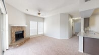 This single-floor residence offers a practical and comfortable layout across two bedrooms and two bathrooms. The open living room serves as the heart of the home, highlighted by a classic brick fireplace with a white mantle, plush neutral carpeting, and a ceiling fan overhead. Natural light flows in through multiple windows fitted with blinds, and a sliding glass door opens to a private balcony with outdoor views. The combined kitchen and living area features a well-equipped galley-style kitchen with rich dark cabinetry, granite-style countertops, a subway tile backsplash, wood-look flooring, and a full suite of stainless steel appliances including a refrigerator, electric range, microwave, and dishwasher. The spacious primary bedroom offers generous proportions, large windows, soft carpeting, and a ceiling fan. The second bedroom is equally comfortable, with carpeted floors, a window, and a ceiling fan. Both bathrooms are finished with matching dark cabinetry, granite-style vanity tops, and wood-look tile flooring, with one bathroom featuring a tub-shower combination. Additional spaces include an entrance, hallway, and a closet, rounding out a cohesive and functional floor plan.