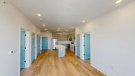 Located at 3818 Page Road in Morrisville, NC, this well-appointed 2-bedroom, 2-bathroom single-floor home offers a thoughtfully designed layout with modern finishes throughout. Light hardwood flooring flows seamlessly across all living areas, creating a warm and cohesive aesthetic.

The kitchen serves as the heart of the home, featuring gray shaker-style cabinetry with matte black hardware, a white quartz island with ample counter space, stainless steel appliances including a refrigerator, range, microwave, and dishwasher, and a classic subway tile backsplash. Recessed lighting illuminates the space efficiently.

Both bedrooms are bright and airy, each equipped with ceiling fans and large windows that invite natural light and outdoor views. The primary bedroom offers access to a private balcony through elegant double French doors. Each bedroom is served by a dedicated walk-in closet, both outfitted with multi-tier wire shelving systems for organized storage.

The primary bathroom is a standout feature, offering a dual-sink vanity with white quartz countertops, matte black fixtures, a large framed mirror, and a glass-enclosed shower. The second bathroom mirrors the same clean, contemporary design with a single-sink vanity and matching finishes. The overall ambiance is bright, clean, and modern.