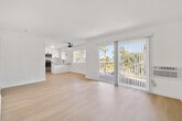 Located at 900 Phillips Street in Vista, CA, this single-story 2-bedroom, 1-bathroom residence offers a clean, modern aesthetic throughout. Light wood-tone flooring runs continuously across all rooms, creating a cohesive and bright interior. The layout includes a dedicated entrance, hallway, and a combined kitchen and living area that serves as the heart of the home.

The kitchen is a standout feature, showcasing white shaker cabinetry with matte black hardware, marble-look quartz countertops, a peninsula for additional prep and dining space, stainless steel appliances, and a window above the sink that draws in natural light. The adjacent living area is open and airy, with a wall-mounted AC unit providing climate control.

Both bedrooms are well-proportioned and bright. The primary bedroom includes a ceiling fan, mirrored sliding closet doors, and an abundance of natural light. The second bedroom also features a ceiling fan and large windows with views of surrounding greenery.

The bathroom is tastefully updated with white shaker vanity cabinetry, quartz countertops, matte black fixtures, a framed mirror, and a tub-shower combination. The overall design palette of crisp white walls, warm flooring, and black accents gives the space a contemporary and inviting character.