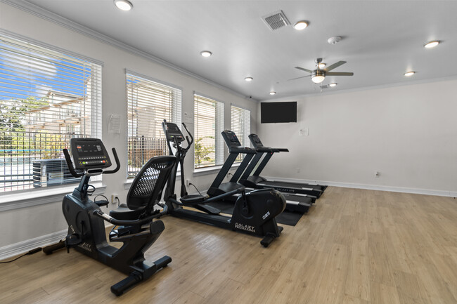 Gym overlooking the pool area - West Park at Downtown