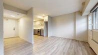 Located at 257 Lisgar St in Ottawa's vibrant Centretown neighbourhood, this well-appointed one-bedroom, one-bathroom unit offers a thoughtfully designed layout finished with contemporary touches throughout. Light hardwood-style flooring runs seamlessly across the entire space, creating a clean, cohesive aesthetic.

The open-concept living and dining area provides a comfortable and versatile space for everyday living, with wide windows along the exterior wall flooding the room with natural light and offering views of the surrounding cityscape. The kitchen is efficiently designed with modern two-tone cabinetry — white uppers and grey lowers — stainless steel appliances including a range and dishwasher, a sleek range hood, and ample counter space, all accessible via an open pass-through layout.

The bedroom is a well-sized private retreat featuring a broad window with city views and generous closet storage. In total, the unit includes three closets, providing excellent organization throughout. The bathroom is finished with contemporary grey cabinetry, a vanity with mirror, and overhead storage. A hallway connects the key areas of the unit, keeping the layout functional and easy to navigate. This space offers a clean, move-in-ready interior ideal for urban living.