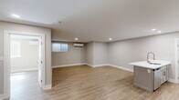 This thoughtfully designed one-bedroom, one-bathroom unit at 204 E Chester Pike in Ridley Park, Pennsylvania offers a well-organized floor plan that makes efficient use of its single-level layout. Light wood-tone luxury vinyl plank flooring runs consistently throughout the space, lending a cohesive, contemporary feel to every room.

The kitchen is a standout feature, showcasing gray shaker-style cabinetry, white quartz countertops, a subway tile backsplash, and a full suite of stainless steel appliances, including a range, microwave, and refrigerator. A peninsula with an integrated sink adds functional counter space and provides a natural division between the kitchen and the open living area, which is illuminated by recessed lighting.

The bedroom is a comfortable, well-proportioned room featuring a window with blinds that allows natural light to filter in, a wall-mounted mini-split HVAC unit for individualized climate control, and recessed lighting above.

The bathroom is finished to a high standard, with large-format marble-look tile in the tub/shower surround, wood-look tile flooring, a white vanity with a gray quartz countertop, and a backlit mirror. Neutral warm-gray walls throughout the unit contribute to a clean, modern ambiance.