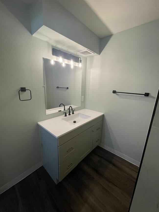 Experimente la elegancia de un baño moderno, con un tocador elegante y una iluminación elegante. - LaRonja Apartments