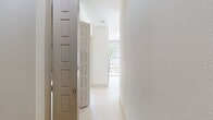 This contemporary apartment, located in the Fiori On Vitruvian Park complex in Addison, Texas, offers a well-designed living space of 1,000 square feet. The layout comprises two bedrooms, with the primary bedroom being exceptionally spacious at 690 square feet. The apartment features one bathroom, equipped with a double vanity with granite countertops and rich wood cabinetry. Two closets provide ample storage space.

The interior is characterized by its modern aesthetic, with light-colored walls and sleek, light wood flooring throughout. Large windows in both bedrooms allow for abundant natural light and offer views of the surrounding area. The living spaces are open and airy, with high ceilings contributing to the sense of spaciousness.

A notable feature is the sliding glass door in one of the bedrooms, which appears to lead to a balcony or patio area, providing an outdoor extension to the living space. The apartment's neutral color palette and clean lines create a canvas for personalization, while ceiling fans in the bedrooms offer additional comfort. Overall, this apartment combines contemporary design with practical living spaces, ideal for those seeking a modern urban lifestyle.
