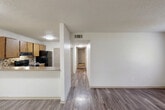 This two-bedroom, two-bathroom single-floor residence in Gadsden, Alabama offers a practical and well-organized layout. The open-concept living and kitchen area serves as the heart of the home, where a peninsula counter separates the two spaces while maintaining a connected, airy feel. The kitchen is equipped with warm oak cabinetry, a tile mosaic backsplash, black appliances including a refrigerator and range, and ample counter space. Hardwood-style flooring runs throughout the main living areas, adding a clean and modern aesthetic.

A central hallway connects the living area to the bedrooms and bathrooms, with closet storage conveniently accessible along the way. The primary bedroom is generously sized and features plush carpeting and a window that brings in natural light. The second bedroom is also carpeted and offers a comfortable, versatile space. Both bathrooms are functional and well-appointed, each featuring a full tub-and-shower combination with white tile surround, a vanity with countertop sink, and a large mirror.

The unit also includes a dedicated laundry area and textured ceilings throughout. The layout is efficient and makes excellent use of the available space, providing a comfortable living environment.