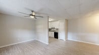 Located at 48 Chateau Dr SE in Rome, Georgia, this single-floor 2-bedroom, 1-bathroom home offers a thoughtfully organized layout that maximizes every square foot. The open-concept living and dining area flows seamlessly into the kitchen, where white shaker-style cabinetry, a tile backsplash, granite-look countertops, and black appliances — including a full-size refrigerator and dishwasher — create a clean, functional space. Light wood-look flooring runs throughout the main living areas, while a ceiling fan with light kit adds comfort and airflow. Natural light enters through front-facing windows, brightening the living space. A hallway connects the main living areas to the private quarters, where two carpeted bedrooms each feature ceiling fans and closet storage. The spacious primary bedroom includes a dedicated closet with a full-length hanging rod. The full bathroom is finished with a white vanity topped with granite counters, a framed mirror, wood-look flooring, and a tiled tub-shower surround. Additional practical spaces include a pantry, utility room, and hallway closet, rounding out this efficiently designed home.