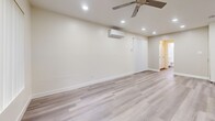 Located at 8382 Whitaker St in Buena Park, CA, this thoughtfully designed one-bedroom, one-bathroom unit offers a clean, modern aesthetic throughout its single floor. Light-toned wood-style flooring flows seamlessly across every room, creating a cohesive and bright interior.

The open-concept living and dining area is generously proportioned, featuring a ceiling fan with integrated lighting, a wall-mounted mini-split HVAC unit for year-round comfort, and vertical blinds over a large window that allows ample natural light.

The kitchen is well-equipped with crisp white shaker cabinetry, granite-style countertops, a stainless steel dishwasher, and recessed lighting overhead. A peninsula provides additional counter space and casual dining potential, while the layout connects naturally to the dining and living area.

The bedroom offers comfortable dimensions, a mirrored sliding-door closet for generous storage, a ceiling fan, and a wall-mounted mini-split unit. A hallway leads to additional closet storage with white built-in cabinetry.

The bathroom features a single-sink vanity with a stone-finish countertop, a tub and shower combination enclosed by sliding glass doors, and a window that brings in natural light. Clean white walls and modern fixtures complete the space's polished presentation throughout.