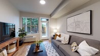 Located at 13470 SE 162nd Ave in Happy Valley, Oregon, this single-story unit offers a thoughtfully designed layout that balances modern finishes with functional living spaces. Light wood-tone flooring flows throughout the main areas, creating a warm and cohesive aesthetic.

The living room is a bright, inviting space anchored by large windows and a glass-panel door that opens directly to a private outdoor area, allowing natural light and views of lush greenery to fill the room. A wall-mounted HVAC unit provides convenient climate control.

The kitchen is well-appointed with dark espresso cabinetry, granite countertops, white subway tile backsplash, and a full suite of stainless steel appliances, including a refrigerator, electric range, microwave, and dishwasher. A peninsula with seating for two pendant lights overhead serves as both a functional workspace and casual dining area, opening seamlessly into the living space.

The bedroom features plush carpeting and neutral tones, offering a quiet retreat. The bathroom includes wood-look flooring, granite-topped vanity cabinetry, and a full soaking tub with shower. The overall ambiance is clean, contemporary, and well-suited for comfortable everyday living.