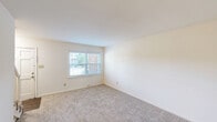 Located at 1220 Carriage House Ln in Gastonia, NC, this two-story residence offers three bedrooms and two bathrooms across two well-proportioned floors. The ground floor features a bright, inviting entryway with light wood-look flooring and windows fitted with white blinds that allow natural light to filter in. The kitchen is a standout space, showcasing white shaker-style cabinetry, stone-look countertops, a white subway tile backsplash, and a full suite of black appliances including a gas range, dishwasher, over-the-range microwave, and refrigerator — all set on durable wood-look flooring. The upper floor houses the three carpeted bedrooms, including a generously sized primary bedroom with ample closet space. The primary bedroom notably features dual closets, providing excellent storage. Both bathrooms are finished with neutral tones, featuring tiled tub-shower combinations with brushed nickel fixtures. Throughout the home, a clean, neutral color palette creates a bright and adaptable ambiance. Windows in the bedrooms overlook the surrounding brick-built neighborhood, while the exterior enjoys views of mature trees, well-maintained green landscaping, and a welcoming community setting.
