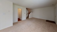Located at 401 Bedford Ln in New Castle, Delaware, this two-floor home offers a practical and comfortable layout designed for everyday living. The main level features a spacious living area finished with neutral-toned carpet, a ceiling fan, and a sliding glass door with vertical blinds that opens to an outdoor space, allowing natural light to fill the room. Adjacent to the living area, a dedicated entryway provides access to the staircase connecting both floors, with warm hardwood-style flooring guiding the way into the functional areas of the home. The kitchen is well-appointed with rich, dark cabinetry, light granite-style countertops, and black appliances including a range, over-the-range microwave, and refrigerator, all set atop durable hardwood-style flooring. A dedicated laundry room houses a stacked washer and dryer unit, adding everyday convenience. The bathroom features a clean, white tub-shower combination with chrome fixtures. Upstairs, the bedrooms offer comfortable carpeted floors and generous natural light through blinded windows. The primary bedroom stands out with dual closets, providing ample storage. Additional bedrooms are bright and versatile. Throughout the home, a clean, neutral palette creates a move-in-ready atmosphere well-suited for a variety of living arrangements.