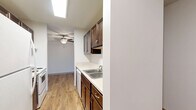 Located on Hubbard Ave N in Robbinsdale, MN, this single-floor residence offers a practical and comfortable layout with two bedrooms, three bathrooms, and a well-connected hallway tying the spaces together. The interior combines warm wood-look hardwood flooring in the main living and hallway areas with plush carpeting throughout the bedrooms, creating a distinction between shared and private spaces. The living area is generously sized, featuring large windows with vertical blinds that allow natural light to fill the room, complemented by baseboard heating and a wall-mounted air conditioning unit for year-round comfort. The primary bedroom is a spacious retreat with dual sliding closet doors and direct access to its own bathroom, as well as an additional walk-in closet area — making it a highly functional private suite. The second bedroom also offers comfortable proportions, natural light, and closet storage. The three bathrooms are clean and well-appointed, featuring dark wood cabinetry with white countertops, medicine cabinet mirrors, and accessible grab bars in at least one bathroom. One bathroom includes a full bathtub and shower surround. Textured ceilings are present throughout, and dark wood-framed interior doors add a cohesive, classic touch to the overall design.
