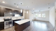 Located at 1851 Knightsbridge Rd in Farmers Branch, Texas, this single-story residence offers a thoughtfully designed layout that maximizes every square foot. The open-concept kitchen and living area form the heart of the home, showcasing rich dark espresso cabinetry, a classic subway tile backsplash, and a large center island with a crisp white countertop — ideal for both meal preparation and casual dining. Pendant lighting above the island adds a modern touch, while stainless steel appliances, including a refrigerator, range, microwave, and dishwasher, complete the kitchen's functional appeal. Hardwood-style flooring flows throughout the main living areas, complemented by neutral walls and ceiling fans that enhance comfort. Large windows invite generous natural light into the living space, creating a bright and airy atmosphere. The bedroom is a serene retreat, carpeted for warmth and comfort, with its own ceiling fan and a window overlooking the outdoors. A well-organized walk-in closet with multiple hanging rods and shelving provides ample storage. The overall design balances contemporary style with practical living, making this a comfortable and efficient home.