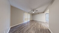 Located in Ridgeland, Mississippi, this well-designed one-bedroom, one-bathroom unit offers a functional and comfortable layout across a single floor. The open living room and kitchen area serves as the heart of the space, featuring durable wood-look flooring, neutral warm-gray walls, and a textured ceiling. A ceiling fan with a built-in light fixture provides both comfort and illumination, while a large sliding glass door dressed with vertical blinds floods the room with natural light. The kitchen is outfitted with rich dark cabinetry, light countertops, a stainless steel sink, dishwasher, and an electric range, providing ample storage and functionality. The spacious bedroom is finished with plush wall-to-wall carpet, a ceiling fan, and a window with blinds that allows for natural light and ventilation. A dedicated closet adds convenient storage. The bathroom features wood-look flooring, dark vanity cabinetry with a white countertop, a large mirror, and a tub-shower combination with white tile surround and brushed nickel fixtures and grab bars. Clean white trim and consistent neutral tones throughout create a cohesive, move-in-ready aesthetic.