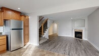 Located at 7275 NE 47th St in Kansas City, MO, this two-story home offers a thoughtfully designed layout spread across two levels, connected by a carpeted staircase with a warm wood banister. The main level features an open living area with wood-look luxury vinyl plank flooring, a fireplace with a tile surround, and recessed lighting that contributes to a bright, welcoming atmosphere. The kitchen is a functional highlight, showcasing warm honey-toned cabinetry with crown molding, dark granite countertops, a subway tile backsplash, tile flooring, and a full suite of stainless steel appliances including a range, microwave, dishwasher, and refrigerator. A hallway connects the main living spaces, with views of the kitchen and access to a bathroom featuring a wood-toned vanity and brushed nickel fixtures.

Upstairs, the bedrooms feature vaulted ceilings with ceiling fans and plush carpeting. The primary bedroom includes a walk-in closet with built-in shelving and multiple windows that allow natural light to fill the space. The full bathrooms are finished with wood-toned vanities, white countertops, and tub-shower combinations. Overall, the home presents a clean, neutral palette throughout.