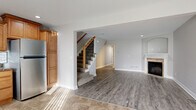 Located at 7275 NE 47th St in Kansas City, MO, this two-story home offers a thoughtfully designed layout spread across two levels, connected by a carpeted staircase with a warm wood banister. The main level features an open living area with wood-look luxury vinyl plank flooring, a fireplace with a tile surround, and recessed lighting that contributes to a bright, welcoming atmosphere. The kitchen is a functional highlight, showcasing warm honey-toned cabinetry with crown molding, dark granite countertops, a subway tile backsplash, tile flooring, and a full suite of stainless steel appliances including a range, microwave, dishwasher, and refrigerator. A hallway connects the main living spaces, with views of the kitchen and access to a bathroom featuring a wood-toned vanity and brushed nickel fixtures.

Upstairs, the bedrooms feature vaulted ceilings with ceiling fans and plush carpeting. The primary bedroom includes a walk-in closet with built-in shelving and multiple windows that allow natural light to fill the space. The full bathrooms are finished with wood-toned vanities, white countertops, and tub-shower combinations. Overall, the home presents a clean, neutral palette throughout.