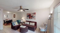 This two-story, 2-bedroom, 1.5-bathroom home offers a thoughtfully arranged layout across two levels. The living room serves as the heart of the main floor, featuring light tile flooring, a ceiling fan, and a window that draws in natural light, creating a warm and inviting atmosphere. Adjacent to the living area, the dining space provides a seamless flow for everyday living and entertaining. The kitchen is well-equipped with white cabinetry, dark granite-style countertops, a tiled backsplash, and black appliances including a range and dishwasher, all set atop easy-to-maintain tile flooring. The half bathroom features a dark granite vanity top with white cabinetry and a sloped ceiling, adding architectural character. Upstairs, the primary bedroom is carpeted and includes a ceiling fan, ample dresser space, and direct access to a full bathroom. The second bedroom is also carpeted, brightened by a large window with blinds and its own ceiling fan. The full bathroom is clean and functional, featuring a tub-shower combination with a tile surround and wood-look flooring. Throughout the home, neutral tones and consistent finishes create a cohesive and comfortable living environment.