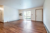Located at 1040 S 25th St in Wausau, Wisconsin, this single-floor unit offers a well-designed, functional layout with a comfortable blend of practical finishes throughout. The open-concept living and kitchen area is a central highlight, featuring rich hardwood-style flooring that extends across the main living space. A ceiling fan with light fixture adds both comfort and character to the living room, which is bathed in natural light from a sliding glass door that opens to a private balcony with outdoor views.

The kitchen is thoughtfully appointed with light oak cabinetry offering generous storage, a peninsula breakfast bar, white appliances including a range, dishwasher, and refrigerator, and ample counter space for meal preparation. A dedicated corridor leads to the private quarters of the unit.

The bedroom is carpeted for warmth and comfort, featuring a large window that invites natural light and a mirrored sliding-door closet. The unit includes two bathrooms — one with a single-stall shower and hardwood-style flooring, and another with a vanity, mirror, and additional storage. In-unit laundry with a full-size washer and dryer provides added convenience. Baseboard heating is present throughout, ensuring year-round comfort in Wisconsin's climate.