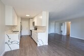 Located at 8440 Fountain Ave in the heart of West Hollywood, California, this single-floor unit offers a clean, modern aesthetic throughout. Light wood-tone flooring runs continuously across all rooms, creating a cohesive and airy feel that enhances the sense of space.

The living area is generously sized and filled with natural light, featuring a ceiling fan and a large sliding glass door that opens onto a private balcony with views of surrounding greenery. A wall-mounted heating unit ensures year-round comfort. An adjacent room provides additional flexible living space, also outfitted with a ceiling fan and a window framing outdoor palm tree views, along with a built-in wall AC unit.

The kitchen is appointed with white shaker cabinetry, marble-look countertops, stainless steel appliances including a range, microwave, and refrigerator, and ample upper and lower cabinet storage. The layout connects efficiently to the main living areas.

The bedroom is well-proportioned, featuring a ceiling fan with light fixture, a smart lock-equipped entry door, and access to both a standard closet and a dedicated walk-in closet, providing excellent storage. The overall color palette throughout the unit is neutral and bright, with white walls and trim contributing to a clean, move-in-ready atmosphere ideal for West Hollywood living.