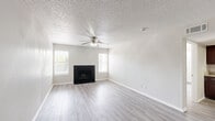 Located at 1595 S Old Orchard Ln in Lewisville, TX, this single-story, 3-bedroom, 4-bathroom home offers a thoughtfully designed layout with consistent finishes throughout. The open living room serves as the heart of the home, featuring light wood-look flooring, a textured ceiling, a ceiling fan, and a striking black-tiled wood-burning fireplace flanked by windows that invite natural light. The adjoining kitchen is equipped with rich dark wood cabinetry, granite-style countertops, and stainless steel appliances including a range and refrigerator. Each of the three bedrooms continues the light flooring and ceiling fan combination, with neutral walls and windows providing natural light and ventilation. The primary bedroom offers a comfortable footprint with ample room for furnishings. The home includes four bathrooms, with the primary bath featuring a wide granite-topped vanity with dark wood cabinetry, a large mirror, and a tub-shower combination. Additional bathrooms offer clean, functional tub-shower setups. Six closets provide generous storage options throughout. A dedicated utility room and consistent neutral color palette complete this well-organized, move-in ready home.