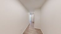 Located at 1100 Boylston Ave in Seattle's Capitol Hill neighborhood, this 2-bedroom, 2-bathroom unit offers a thoughtfully designed single-floor layout with a clean, contemporary aesthetic throughout. Light-toned wood-style flooring runs continuously across the space, complementing the crisp white walls and recessed lighting that create a bright, modern atmosphere.

The open-concept kitchen and living area serves as the heart of the unit, featuring a sleek white waterfall island with an undermount sink, light wood cabinetry extending to the ceiling, subway tile backsplash, and a full suite of stainless steel appliances including a refrigerator, range, and microwave. Large windows flood the living area with natural light and frame views of the surrounding Seattle cityscape.

Both bedrooms are well-proportioned, each benefiting from oversized windows that bring in ample daylight and urban views. A wall-mounted mini-split unit provides climate control in the main living area. The two bathrooms are finished with clean, modern fixtures — one features a soaking tub with tiled surround and a glass shower rod, while the other includes a single vanity with white countertop and taupe cabinetry. A central hallway connects the rooms efficiently, and two closets provide dedicated storage. The overall design is minimal, functional, and move-in ready.