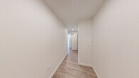 Located at 1100 Boylston Ave in Seattle's Capitol Hill neighborhood, this 2-bedroom, 2-bathroom unit offers a thoughtfully designed single-floor layout with a clean, contemporary aesthetic throughout. Light-toned wood-style flooring runs continuously across the space, complementing the crisp white walls and recessed lighting that create a bright, modern atmosphere.

The open-concept kitchen and living area serves as the heart of the unit, featuring a sleek white waterfall island with an undermount sink, light wood cabinetry extending to the ceiling, subway tile backsplash, and a full suite of stainless steel appliances including a refrigerator, range, and microwave. Large windows flood the living area with natural light and frame views of the surrounding Seattle cityscape.

Both bedrooms are well-proportioned, each benefiting from oversized windows that bring in ample daylight and urban views. A wall-mounted mini-split unit provides climate control in the main living area. The two bathrooms are finished with clean, modern fixtures — one features a soaking tub with tiled surround and a glass shower rod, while the other includes a single vanity with white countertop and taupe cabinetry. A central hallway connects the rooms efficiently, and two closets provide dedicated storage. The overall design is minimal, functional, and move-in ready.