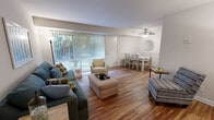 Located at 7703 Enfield Ave in Norfolk, VA, this two-bedroom, one-bathroom single-floor residence offers a thoughtfully laid-out living space. The combined living and dining area serves as the heart of the home, featuring warm hardwood-style flooring, a ceiling fan, and a large sliding glass door that floods the space with natural light and provides views of the surrounding greenery. The dining area is accented by a chair-rail detail and a decorative round mirror, adding a touch of classic charm.

The kitchen is well-appointed with warm wood cabinetry, granite-look countertops, a mosaic tile backsplash, a dishwasher, and in-unit laundry. A pantry provides additional storage convenience.

The primary bedroom offers comfortable carpeting, a sizable closet, and a sliding glass door that opens to outdoor views. The second bedroom is equally well-lit, also featuring a closet and access to natural light. Both rooms share a clean, functional full bathroom.

A welcoming hallway with hardwood-style flooring connects the living areas to the private quarters, complemented by ample closet storage throughout. The single-floor layout ensures easy accessibility, making this Norfolk residence a practical and comfortable place to call home.