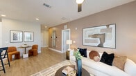 Located along SR-46 in Sanford, Florida, this single-story, 3-bedroom, 2-bathroom home offers a thoughtfully designed layout with modern finishes throughout. The open-concept kitchen and living area serves as the heart of the home, featuring light wood-style flooring, recessed lighting, and pendant lights over a spacious island with bar seating. The kitchen is outfitted with white upper cabinetry, grey lower cabinets, stainless steel appliances, and clean white countertops. The adjoining living room is bright and welcoming, with large windows that invite natural light and a ceiling fan overhead. A hallway with carpeted flooring connects the three bedrooms, which transition seamlessly from the common areas. The primary bedroom is a comfortable retreat with plush carpet, a ceiling fan, and generous proportions. The primary bathroom impresses with wood-style flooring, grey cabinetry, a dual-sink vanity, and a floor-to-ceiling marble-tiled walk-in shower. The second bathroom features a tub-shower combo, grey cabinetry, and a wide vanity mirror. Two closets provide ample storage, while the dedicated laundry room accommodates a full-size washer and dryer. Neutral tones and cohesive finishes give the entire home a clean, contemporary feel.