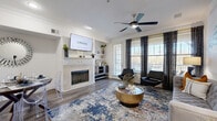 This multi-floor home in Round Rock, Texas offers four bedrooms and five bathrooms spread across three levels, delivering a well-organized and functional layout. The ground level houses an attached garage with built-in shelving and automatic opener. The main living floor is anchored by a combined kitchen and living room that serves as the heart of the home. The living area features rich hardwood-style flooring, crown molding, a ceiling fan, and a tiled fireplace flanked by open shelving — all bathed in natural light from large windows with stylish draping. Adjacent to the living space, a dedicated dining area rounds out the open-concept feel. The galley-style kitchen is outfitted with white shaker cabinetry, light quartz countertops, a full suite of stainless steel appliances, and a built-in sink, offering both style and practicality. The upper floor hosts the bedrooms, including a generously sized primary suite with an en-suite bathroom and walk-in closet complete with built-in shelving. Additional bathrooms feature clean white tile tub-shower combinations with hardwood-style flooring. A dedicated laundry area with full-size washer and dryer units adds everyday convenience. Throughout, the clean white walls, consistent flooring, and thoughtful details create a cohesive and contemporary living environment.