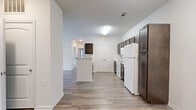 Located at 3051 Lumby Dr in Decatur, GA, this single-floor residence offers three bedrooms and two bathrooms within a thoughtfully organized layout. The kitchen is a standout feature, showcasing rich dark-stained cabinetry with brushed nickel hardware, light marble-style countertops, and white appliances including a refrigerator, range, and over-the-range microwave. Wood-look plank flooring runs through the kitchen and extends into the living room, which benefits from natural light through multiple windows and a glass door, complemented by a ceiling fan overhead. The bedrooms are carpeted for comfort, each featuring ceiling fans and natural light from windows with blinds. The spacious primary bedroom provides a comfortable retreat with generous proportions. The two bathrooms are finished consistently, featuring dark wood vanities with marble-style countertops, large mirrors with vanity lighting, and light tile flooring. One bathroom includes a tub-shower combination, while the other offers an open shower setup. A dedicated hallway and closet provide additional storage and circulation throughout the home. Neutral wall tones and clean finishes give the space a bright, move-in-ready feel throughout.