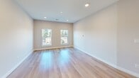 Located at 59 Mill St in Woburn, MA, this thoughtfully designed 2-bedroom, 2-bathroom residence offers a clean, modern aesthetic with high-quality finishes throughout. The open-concept living area seamlessly connects the dining and living spaces to a well-appointed kitchen, which features white shaker cabinetry, subway tile backsplash, quartz countertops, stainless steel appliances including a range, microwave, and refrigerator, and a central island ideal for casual dining or meal prep. Light-toned hardwood flooring runs throughout the home, enhancing the bright and airy atmosphere created by recessed lighting and large windows. The primary bedroom is generously sized and includes sliding glass doors that open to a private balcony with outdoor views, while the second bedroom benefits from dual windows that invite ample natural light. Both bedrooms offer convenient closet access. The two bathrooms are finished with subway tile, stone-look tile flooring, and brushed nickel fixtures — one featuring a soaking tub and shower combo, the other a walk-in shower with a sleek sliding glass enclosure. Additional highlights include an in-unit laundry, a utility room, and six closets providing excellent storage throughout.