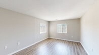 This single-story, 2-bedroom, 2-bathroom home in Durham, NC offers a clean, modern aesthetic throughout. The open living area features wood-look laminate flooring and multiple windows with slatted blinds, allowing natural light to fill the space while maintaining privacy. Neutral gray walls and crisp white trim create a cohesive, contemporary palette throughout.

The kitchen is well-appointed with dark espresso cabinetry, granite-look countertops, and a full suite of stainless steel appliances including a range, over-the-range microwave, dishwasher, and refrigerator. The wood-look flooring continues seamlessly into this space.

Both bedrooms are comfortably sized, with the primary bedroom offering generous proportions and plush carpeting underfoot. The second bedroom also features carpet and is served by its own closet. A spacious walk-in closet with wire shelving and hanging rods provides excellent storage capacity. The bathrooms include a tub-shower combination with brushed nickel fixtures.

A dedicated laundry area includes washer and dryer hookups, adding everyday convenience. The thoughtful single-level layout connects all rooms through a central hallway, making this Durham home a practical and welcoming space.
