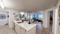 Located at 500 SW 5th Pl in Renton, WA, this well-appointed 2-bedroom, 2-bathroom residence offers a thoughtfully designed single-level layout. The open-concept kitchen flows seamlessly into the living area, anchored by a large white quartz peninsula with an undermount sink — ideal for both meal prep and casual dining. The kitchen features white cabinetry, stainless steel appliances including a range and refrigerator, track lighting, and hardwood-style flooring. The living room is bright and welcoming, with a bank of windows offering treetop views, a cozy fireplace, and plush carpeting. Both bedrooms are generously sized, each with windows that invite natural light and carpet flooring. The primary bedroom provides a comfortable retreat, while the second bedroom is versatile enough to serve as a guest room or office. Each full bathroom includes a tub/shower combo with classic tile flooring. A dedicated in-unit laundry room houses a full-size washer and dryer alongside a water heater, adding everyday convenience. The overall ambiance is clean, bright, and functional — a practical yet comfortable home in a convenient Renton location.