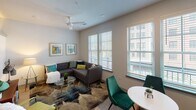 Located at 577 Meeting St in Charleston's vibrant downtown, this single-floor unit offers a thoughtfully designed open layout with modern finishes throughout. The living area is bright and inviting, featuring large windows with slatted blinds that allow ample natural light to filter in, complemented by a ceiling fan and neutral walls that create a comfortable, airy atmosphere. The space accommodates both a seating area and a dedicated dining space with ease.

The kitchen is well-appointed with warm-toned wood cabinetry extending to the ceiling, light stone-look countertops, a white subway tile backsplash, and a full suite of stainless steel appliances, including an electric range, built-in microwave, dishwasher, and refrigerator. A single-basin stainless steel sink anchors the counter space, making this an efficient and attractive cooking area.

The bedroom is a calm retreat featuring light wood-look flooring, neutral walls, and a sliding-door closet providing generous storage. The bathroom is clean and modern, with warm wood vanity cabinetry, stone-look countertops, light wood-look tile flooring, and a full tub-shower combination with white surround. Recessed lighting throughout maintains a consistent, polished aesthetic across the entire unit.