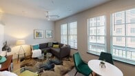 Located at 577 Meeting St in Charleston's vibrant downtown, this single-floor unit offers a thoughtfully designed open layout with modern finishes throughout. The living area is bright and inviting, featuring large windows with slatted blinds that allow ample natural light to filter in, complemented by a ceiling fan and neutral walls that create a comfortable, airy atmosphere. The space accommodates both a seating area and a dedicated dining space with ease.

The kitchen is well-appointed with warm-toned wood cabinetry extending to the ceiling, light stone-look countertops, a white subway tile backsplash, and a full suite of stainless steel appliances, including an electric range, built-in microwave, dishwasher, and refrigerator. A single-basin stainless steel sink anchors the counter space, making this an efficient and attractive cooking area.

The bedroom is a calm retreat featuring light wood-look flooring, neutral walls, and a sliding-door closet providing generous storage. The bathroom is clean and modern, with warm wood vanity cabinetry, stone-look countertops, light wood-look tile flooring, and a full tub-shower combination with white surround. Recessed lighting throughout maintains a consistent, polished aesthetic across the entire unit.