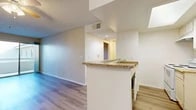 Located at 835 S Brookhurst St in Anaheim, CA, this single-story 1-bedroom, 2-bathroom residence offers a thoughtfully arranged floor plan that maximizes functionality. Light wood-style flooring runs throughout the home, creating a cohesive and clean aesthetic. The combined living, dining, and kitchen area forms the heart of the space, featuring a peninsula with granite countertops, white cabinetry, and an open layout that encourages easy flow between cooking and entertaining areas. A ceiling fan overhead adds comfort to the living space. The bedroom is a comfortable size, fitted with mirrored sliding closet doors that reflect natural light from a well-placed window, and connects to the hallway with access to both bathrooms. In total, three closets provide generous storage throughout the unit. One of the bathrooms includes a tub-shower combination with clean white tile surround. A sliding glass door in the living area opens to a private balcony, bringing in natural light and outdoor views. Textured ceilings and neutral warm-toned walls give the home a welcoming, move-in-ready ambiance. A hallway connects all rooms efficiently, and the overall layout is compact yet well-organized for comfortable everyday living.