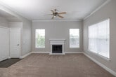 This single-floor residence offers a thoughtfully designed layout with a range of functional and attractive features throughout. The spacious living room serves as the heart of the home, anchored by a classic white-mantled fireplace and framed by multiple windows fitted with white blinds that allow generous natural light to fill the room. Crown molding and a ceiling fan add refined detail to the space, while plush wall-to-wall carpeting extends a warm, comfortable feel underfoot. An elegant arched entryway connects the living area to the rest of the home, enhancing the open flow of the floor plan.

The kitchen is well-equipped, featuring warm maple cabinetry, dark granite countertops, a decorative tile backsplash, and black appliances including a range, microwave, and refrigerator. A peninsula with a built-in sink and pendant lighting above provides both additional prep space and a natural transition into the adjoining living area, which is further lit by track lighting.

The bedrooms are generously sized, each featuring soft carpeting, ceiling fans, and windows that bring in outside views. Several rooms include access to walk-in closets for ample storage. The bathrooms are well-appointed with light wood cabinetry, extended vanities with dual sinks, large mirrors, and light wood-style flooring, offering a clean and functional design throughout.