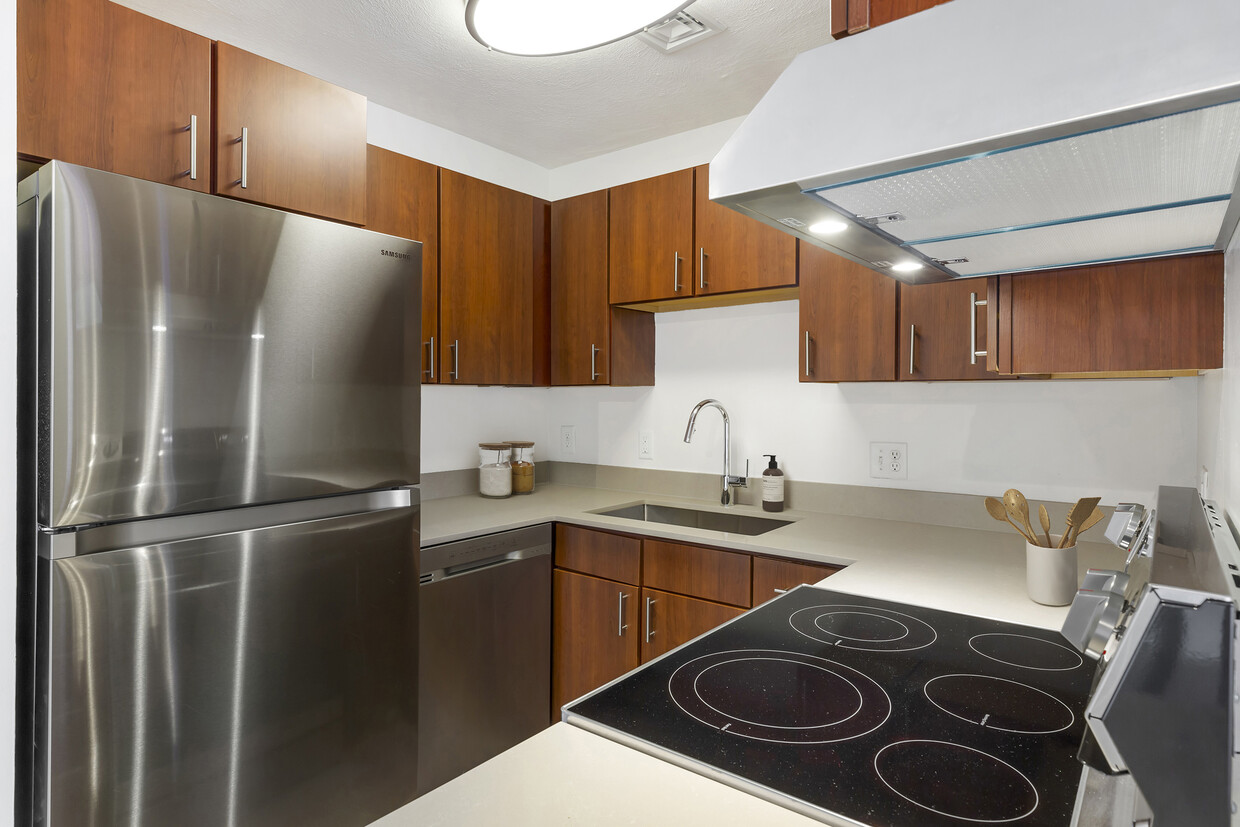 Renovated Package III kitchen with stainless steel appliances, grey quartz countertops, white or cherry cabinetry, and hard surface flooring - eaves Quincy