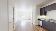 Located at 470 Alexander Loop in Eugene, Oregon, this one-bedroom, one-bathroom residence offers a thoughtfully designed single-floor layout that maximizes functionality and comfort. The open-concept living and kitchen area features warm luxury vinyl plank flooring throughout, creating a bright and cohesive feel. The kitchen is equipped with sleek dark cabinetry, stainless steel appliances including a refrigerator, range, microwave, and dishwasher, along with a built-in sink and ample counter space. The layout flows naturally from the kitchen into the living area, offering a spacious and airy atmosphere. The bedroom is carpeted for comfort and includes a sliding door closet for storage, as well as convenient in-unit washer and dryer access through a dedicated utility area. A sliding glass door opens directly onto a private balcony surrounded by mature trees, filling the space with natural light and greenery. The bathroom features hardwood-style flooring, a dark wood vanity with countertop, and clean white walls with chrome fixtures. A connecting hallway ties all rooms together efficiently. This residence combines modern design elements with practical living features in a serene Eugene setting.