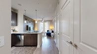 This thoughtfully designed 1-bedroom, 1-bathroom unit offers a cohesive open-concept layout across a single floor. The kitchen and living room flow seamlessly together, anchored by a granite-topped island with bar seating and pendant lighting overhead. Dark espresso cabinetry — including glass-front upper cabinets — pairs with light granite countertops and a full suite of stainless steel appliances, including a refrigerator, range, microwave, and dishwasher. Wood-look flooring runs throughout the main living areas, adding warmth and continuity.

The living room is bathed in natural light from large windows and a glass door that opens to the outdoors, complemented by a ceiling fan. The bedroom offers plush carpeting, multiple windows with natural views, and a ceiling fan, creating a calm and comfortable retreat. Three closets provide ample storage throughout the unit.

The bathroom features a wide, dark-cabinetry vanity with dual sinks and granite countertops, a large framed mirror, and wood-look flooring. In-unit laundry adds everyday convenience. With track lighting, recessed fixtures, and modern hardware throughout, this unit presents a polished, contemporary aesthetic.