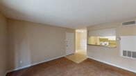 Located in Conroe, TX, this single-floor, 1-bedroom, 1-bathroom unit offers a well-organized layout designed for comfortable everyday living. The living area features neutral-toned carpet and warm beige walls, creating a cozy atmosphere. A pass-through opening connects the living space to the kitchen, enhancing the open feel. The kitchen is designed in a galley style, equipped with white cabinetry, a coil electric range, a refrigerator, and a sink with laminate countertops, all set on light ceramic tile flooring. A tiled entryway leads from the front door into the main living space, providing a clean transition point. The living room also features a sliding glass door dressed with vertical blinds, allowing for natural light and outdoor access. The bedroom is generously sized with plush carpet, a ceiling fan with integrated lighting, and a window that brings in additional natural light. The bathroom includes a full tub and shower combination with white square tile surround, a toilet, and overhead cabinetry for storage. Throughout the unit, clean white trim and consistent neutral finishes contribute to a cohesive and functional living environment.